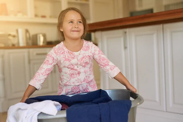 若い頃から家事を手伝うことを学ぶ。洗濯籠を持っている少女のショット. — ストック写真