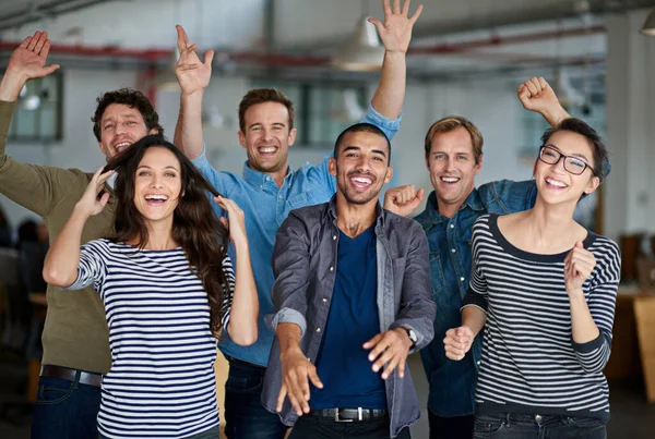 Now thats what I call team spirit. Joyous group of office staff jumping around and having fun together.