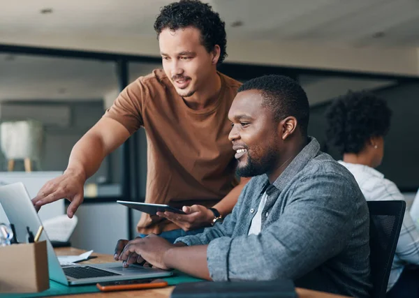 Le travail d'équipe facilite tout. Prise de vue de deux jeunes hommes d'affaires travaillant ensemble dans un bureau. — Photo