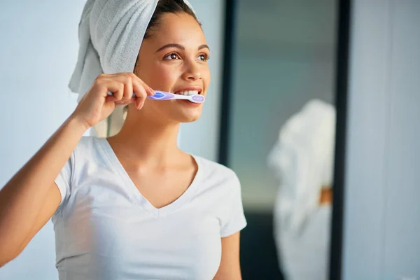 Witam nowy dzień ze świeżym oddechem. Strzał atrakcyjnej młodej kobiety myjącej zęby w domu. — Zdjęcie stockowe