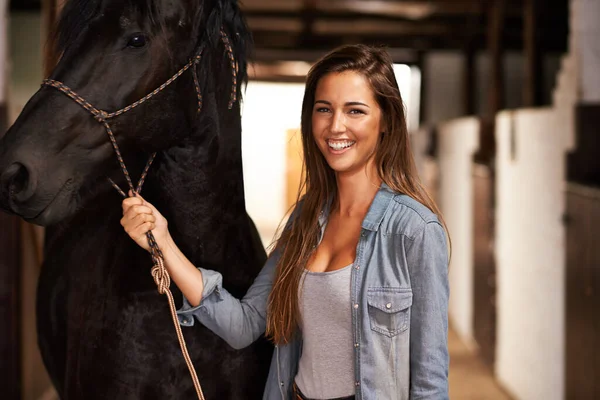 Meisje, waarom? Portret van een jonge vrouw in een stal met haar paard. — Stockfoto