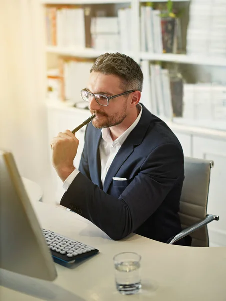 Als er een oplossing is, kan de hel die vinden. Een foto van een zakenman die achter zijn computer werkt in een kantoor.. — Stockfoto