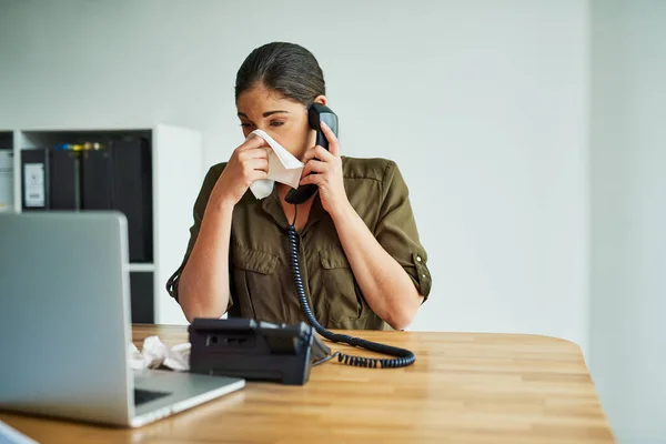 Det är ett outhärdligt tillstånd att arbeta i. Skjuten av en ung affärskvinna som snyftar när hon pratar i telefon på ett kontor.. — Stockfoto