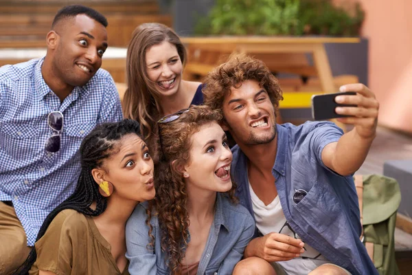 Allemaal aan boord van de Selfie Express. Een groepsfoto van universiteitsstudenten die plezier hebben op de campus. — Stockfoto