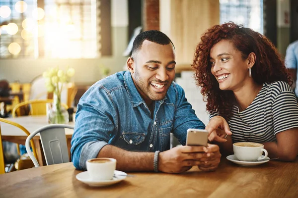 Lembro-me deste dia.... Tiro cortado de um jovem casal afetuoso olhando para um celular enquanto sentado em uma cafeteria. — Fotografia de Stock