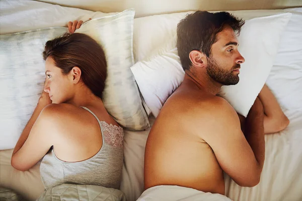 This is what weve become.... High angle shot of an arguing couple with their backs turned on each other in bed. — Stock Photo, Image