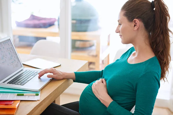 İlk kez anne olacak anneler için online ipuçları. Evde bilgisayarını kullanan hamile bir kadının fotoğrafı.. — Stok fotoğraf