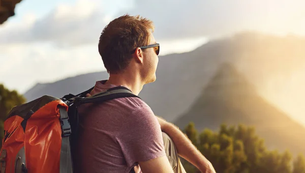 Man kann weiter reisen und mehr erreichen, als man denkt. Aufnahme eines jungen Mannes, der die Aussicht vom Gipfel eines Berges bewundert. — Stockfoto