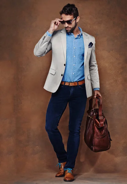 Taking his style on the move. Studio shot of a stylishly dressed young man. — Stock Photo, Image