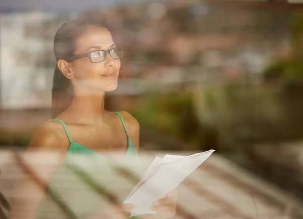 Op zoek naar kansen aan de horizon. Een bijgesneden opname van een jonge vrouw die een document binnen vasthield. — Stockfoto