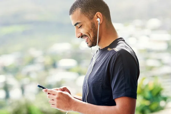 Establecer la lista de reproducción perfecta para motivarlo. Recortado disparo de un joven deportista comprobando su lista de reproducción antes de una carrera. — Foto de Stock