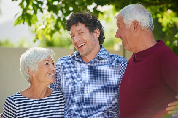 They couldnt be more proud. Cropped shot of a senior couple standing outside with their son. — Foto de Stock