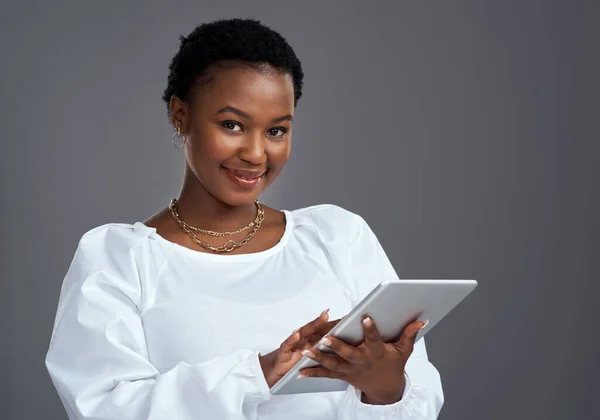Rengeteg gyors és egyszerű módja van annak, hogy pénzt online. Digitális táblagépet használó fiatal nő fotózása szürke háttérrel szemben. — Stock Fotó