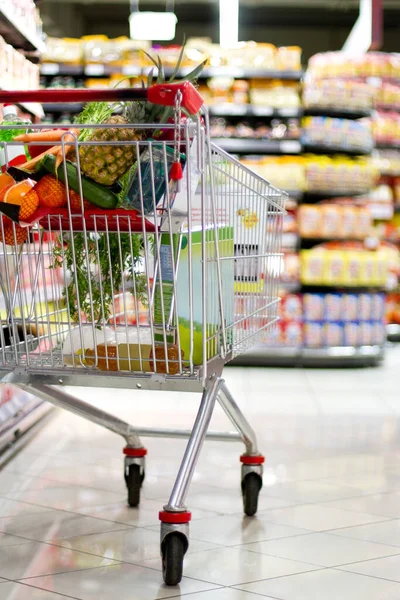 Di supermarket. Sebuah gerobak belanja diisi dengan bahan makanan segar. — Stok Foto