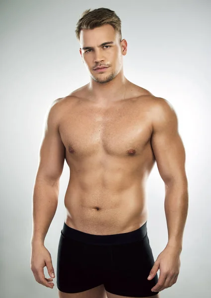 La duda te hace débil. Retrato de estudio de un joven musculoso posando sobre un fondo gris. —  Fotos de Stock