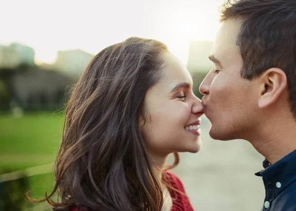 Liebe, sonst nichts. Aufnahme eines jungen Mannes, der seine Freundin im Freien auf die Nase küsst. — Stockfoto