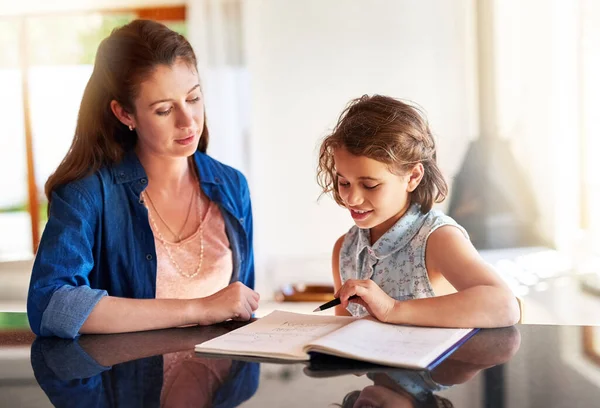 Öğrenmeyi seven çocuklar yetiştirmek. Bir annenin, kızına ev ödevinde yardım ederken çekilmiş bir fotoğrafı.. — Stok fotoğraf