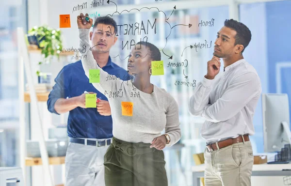 The solution to our problem is easy.... Shot of three coworkers brainstorming in a modern office. — Foto de Stock