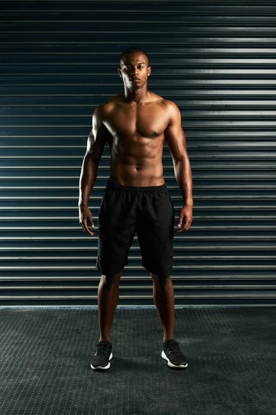 Gebouwd als een god. Full length portret van een atletische jongeman poseren shirtloos in de studio. — Stockfoto