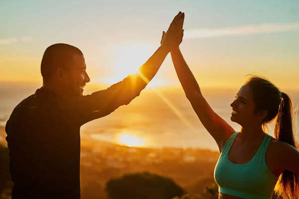 Well done. Cropped shot of two young people high fiving during their workout. — Stock Photo, Image