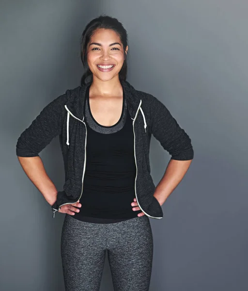 In shape and feeling great. Portrait of a fit young woman in sports clothing posing against a gray background. — Stock Photo, Image