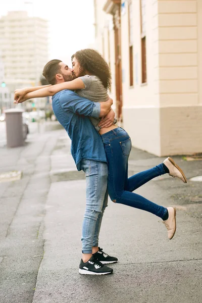 He knocks me off my feet. Shot of a loving couple out in the city. — Stock Photo, Image
