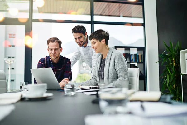 Sie sind ihrem Ziel so nahe. Schnappschuss einer Gruppe von Geschäftsleuten, die gemeinsam an einem Laptop in einem modernen Büro arbeiten. — Stockfoto