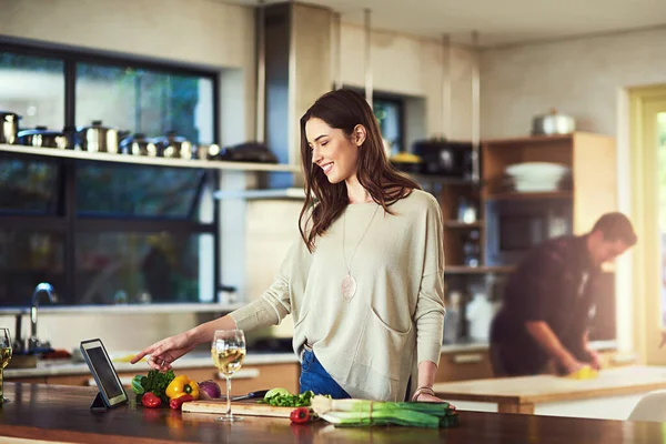 Esta receta es una de las más fáciles de hacer. Recorte de una joven mujer preparando una comida con su novio en el fondo en casa. — Foto de Stock