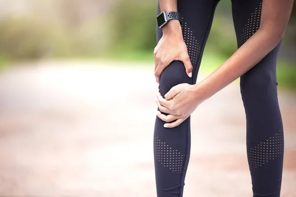Powinienem najpierw się tym zająć. Zbliżenie kobiety odczuwającej ból kolana podczas ćwiczeń na świeżym powietrzu. — Zdjęcie stockowe