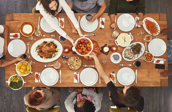 Muistoja tehdään, kun ne kootaan pöydän ympärille. Laukaus ryhmä ihmisiä istuu yhdessä ruokapöydässä valmis syömään. — kuvapankkivalokuva