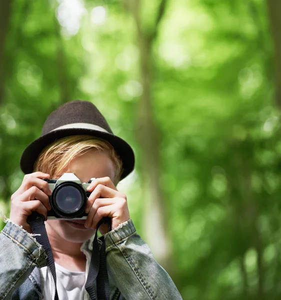 Den perfekten Schuss eingefangen. Nahaufnahme Porträt eines jungen Mannes beim Fotografieren mit einer Oldtimer-Kamera im Wald. — Stockfoto