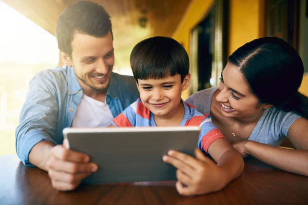 Ci sono alcune applicazioni di apprendimento fresco qui. Colpo ritagliato di una giovane famiglia affettuosa utilizzando un tablet insieme a casa. — Foto Stock