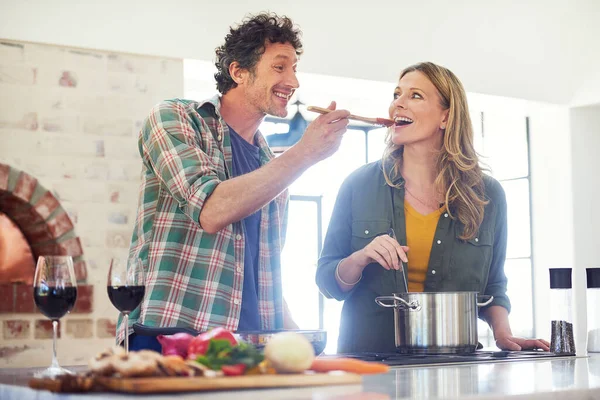 Wat denk je, lieverd? Shot van een gelukkig volwassen paar het bereiden van een maaltijd samen thuis. — Stockfoto