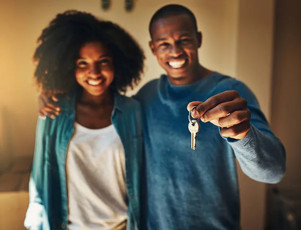 Sono le nostre chiavi del castello. Ritratto di una giovane coppia allegra in piedi insieme mentre sorregge un paio di chiavi della loro nuova casa. — Foto Stock
