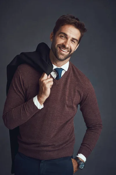 El hombre consciente de estilo. Retrato del estudio de un joven vestido con estilo llevando su chaqueta sobre un fondo gris. — Foto de Stock