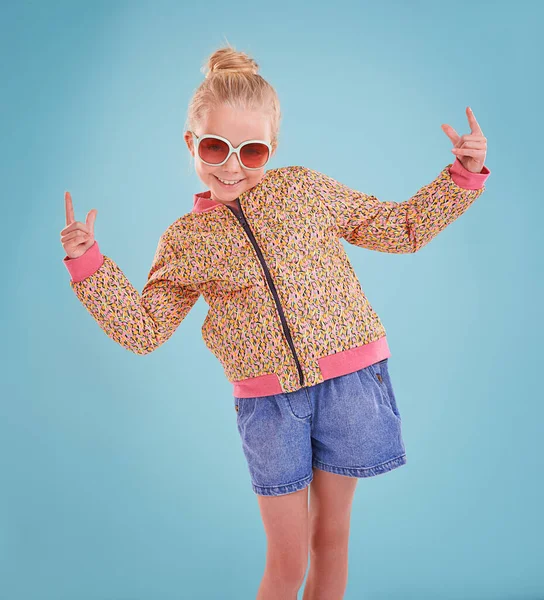 Mostrando mis movimientos funky. Foto de estudio de una niña pequeña con gafas funky sobre un fondo azul. —  Fotos de Stock