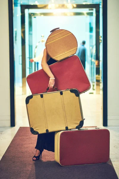 Felizmente, tenho tudo o que preciso. Tiro de uma jovem irreconhecível carregando um monte de bagagem enquanto tentava descer o átrio de um hotel. — Fotografia de Stock