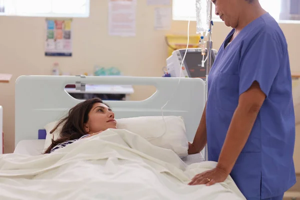 Ik hoop dat het goed nieuws is... Shot van een verpleegster praten met haar patiënt. — Stockfoto