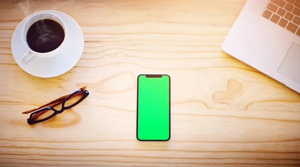 Gjør jobben på egen hånd, ingen ekstra hender behøves. Høyvinklet bilde av en smarttelefon som viser en kromnøkkel på skjermen i et kontormiljø. – stockfoto