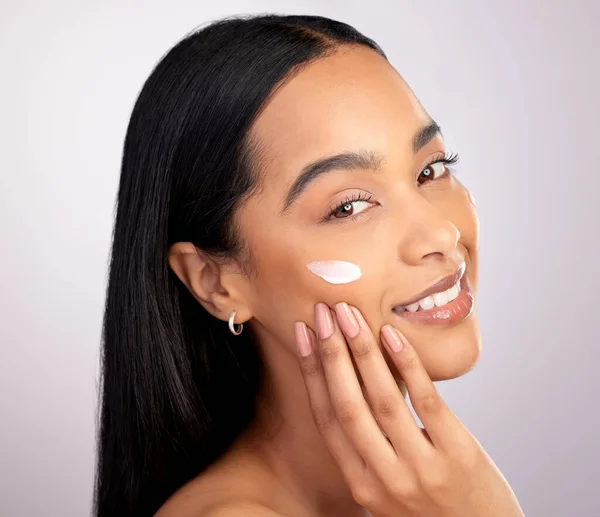 Cuidar tu piel no tiene que ser una tarea. Retrato de estudio de una atractiva joven que se aplica crema hidratante en la cara sobre un fondo rosa. — Foto de Stock