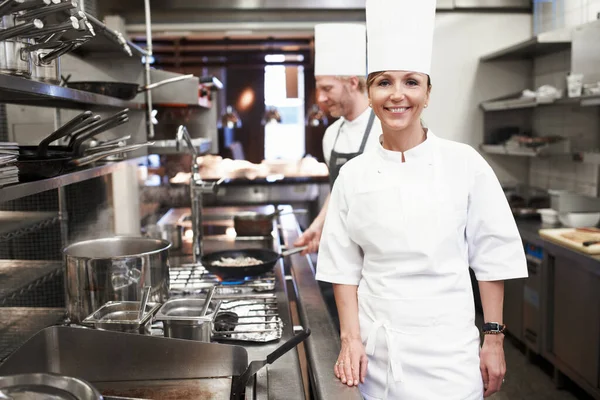 Hon är köksmästare. Porträtt av en kock i ett professionellt kök. — Stockfoto