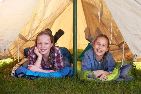 Acampar é o melhor. Duas meninas deitadas em seus sacos de dormir em sua tenda. — Fotografia de Stock
