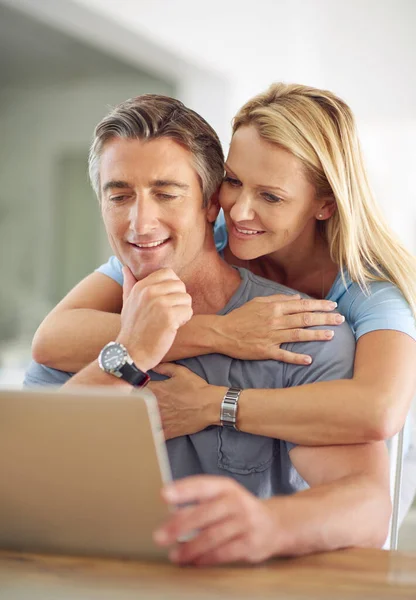 Connected in more ways than one. Shot of a happy mature couple using a laptop at home. — Stock Photo, Image