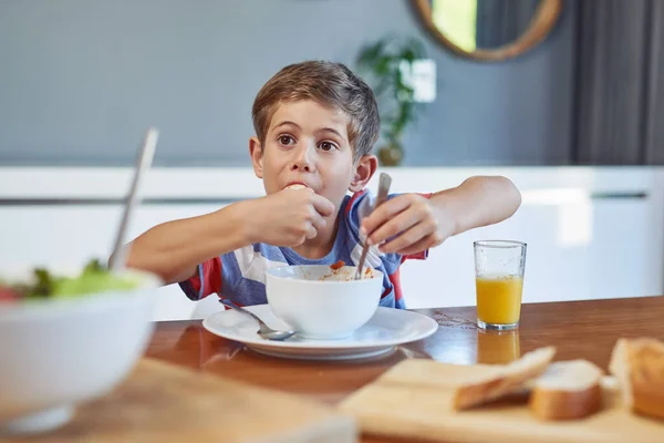 Isto é tão delicioso. Tiro de um menino adorável desfrutando de uma refeição em casa. — Fotografia de Stock