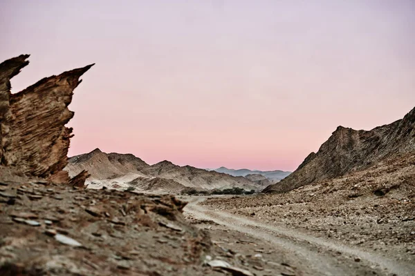 Genom ett utomvärldsligt landskap. Skjuten av en grusväg som går genom oländig terräng. — Stockfoto