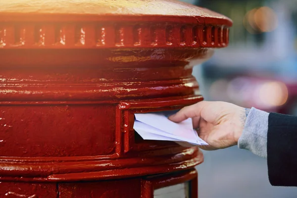 Vermitteln Sie Ihre Botschaft auf die alte Art und Weise. Schnappschuss eines Mannes, der Post in einen Briefkasten in der Stadt wirft. — Stockfoto