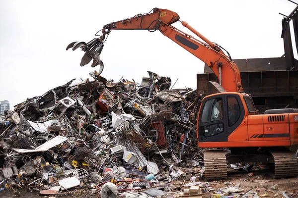 Bearbetar industriavfall. Beskuren bild av en kran på jobbet på en soptipp. — Stockfoto