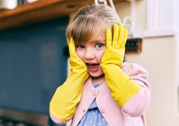 Non c'e 'tempo per lavare i piatti. Ritratto di una bambina sorpresa che si tiene il viso con le mani mentre indossa guanti gialli per lavare i piatti. — Foto Stock