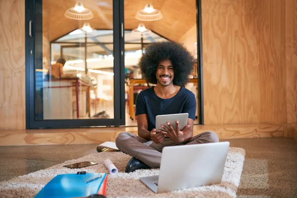 With wireless tools, I can work just about anywhere. Portrait of a young designer working on the floor in an office. —  Fotos de Stock