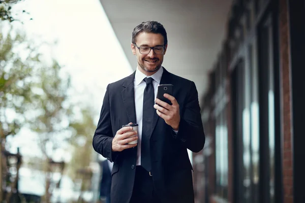 Genieten van de flexibiliteit van draadloos werken. Shot van een volwassen zakenman sms 'en op een mobiele telefoon, terwijl in de stad. — Stockfoto
